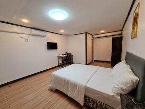 Hideaways Restobar and Resort的卧室配有白色的床和书桌