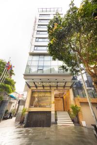 河内Sen Luxury Hotel - Managed by Sen Hotel Group的前面有一间商店的高楼