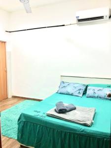 哥打丁宜Isyfaq Homestay 2 bedroom & 2 bathroom的一张带绿毯和枕头的床