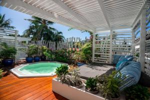 努美阿乐拉冈酒店的一个带热水浴缸和盆栽植物的庭院