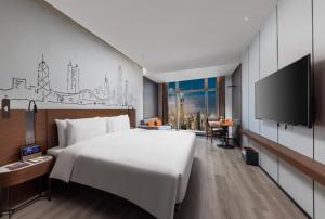 深圳深圳车公庙逸扉酒店的一间酒店客房,配有一张大床和一台平面电视