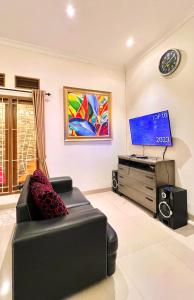 巴图Vila Kusuma Estate Batu的带沙发和平面电视的客厅