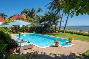 拉迈Beachfront Villa Baan Rim Haad 3BR的一个带遮阳伞的游泳池以及大海