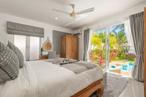 拉迈Beachfront Villa Baan Rim Haad 3BR的一间卧室设有一张床和一个大窗户
