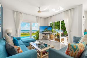 拉迈Beachfront Villa Baan Rim Haad 3BR的客厅配有蓝色的家具,享有海景。