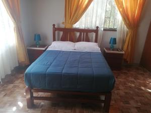 纳斯卡LA FAMILIA NASCA HOUSE的一间卧室配有一张带蓝色毯子的床