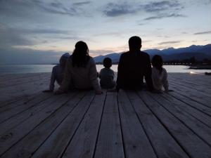 博斯特里Bely Parus的坐在码头上观看日落的家庭