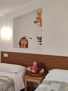 卡拉马尼科泰尔梅Amoroso's house, affittacamere的一间卧室配有两张床,一张桌子上备有一篮玩具