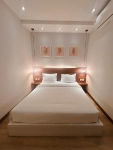巴淡岛中心oxy suites G-01 at Shop House Meisterstadt Pollux Habibie的卧室配有一张带两个枕头的大白色床