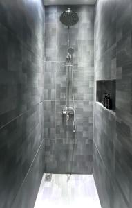 巴淡岛中心oxy suites G-01 at Shop House Meisterstadt Pollux Habibie的浴室设有灰色瓷砖淋浴。