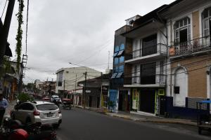 伊基托斯SELVA VIVA IQUITOS的一辆汽车驶向城市街道,街道上有许多建筑