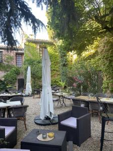 Vergèze西番莲酒店的一个带桌椅和遮阳伞的庭院