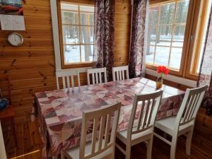 VaalaVilla Sarastus的一间带桌椅和窗户的用餐室