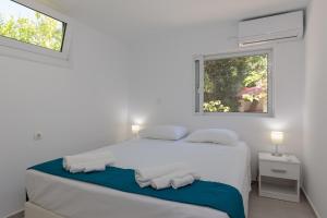 法里拉基Angelana Beach Villa的白色的卧室设有床和窗户