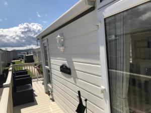 拉尔Hot Tub Accommodation North Wales Caravan的一只黑猫站在房子的一边