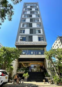 岘港Helios Boutique Hotel & Spa的一座高大的建筑,前面有一间餐厅