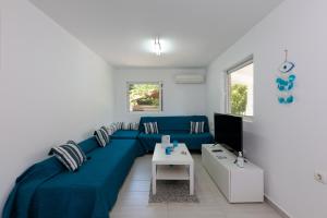 法里拉基Angelana Beach Villa的客厅配有蓝色的沙发和电视