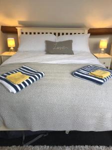 斯卡伯勒Granby House Holiday Apartments, Apartment 3, formerly Sandy Palms的一张白色的床,上面有两条毛巾