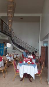 达累斯萨拉姆Sophia Hotel的一群坐在餐厅桌子上的人
