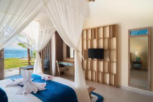 珀尼达岛The Sankara Beach Resort - Nusa Penida的一间卧室设有一张床,享有海景