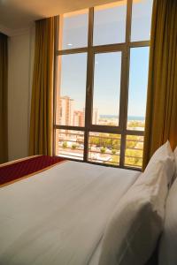 科威特De Iris Regency Fahaheel的一间卧室设有一张床和一个大窗户