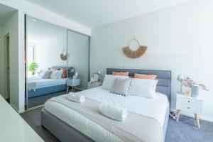 凯阿玛Surf Beach Retreat - 100m from the beach的卧室配有一张白色大床和镜子