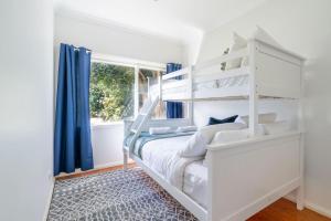凯阿玛The Farmer s Retreat的白色的卧室设有白色双层床和窗户。