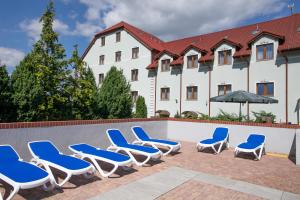 斯拉百斯宏达酒店的一组蓝色和白色的椅子,在游泳池边