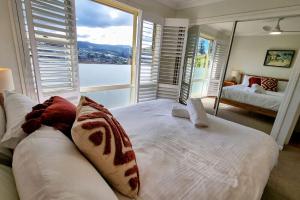 杰林冈Blue Skies Beach House的卧室设有白色的床和大窗户