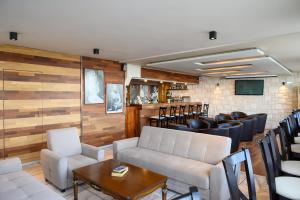 阿基欧斯尼古拉斯艾尔格列柯酒店的客房设有带皮椅和桌子的酒吧。
