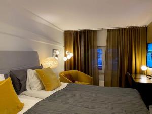 法尔雪平Hotell Syfabriken的酒店客房设有一张大床和一张书桌。
