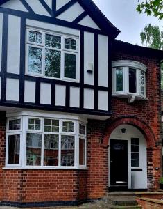 诺丁汉Mapperley Park Guesthouse的红砖房子,有黑白建筑