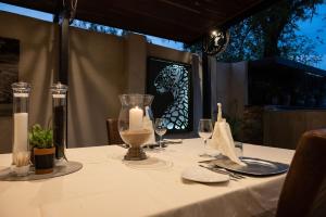 卡萨内Chobe River Lodge的一张桌子,上面有一张蜡烛,上面有白色的桌布