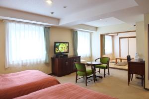 千岁千岁站酒店的一间酒店客房,配有两张床、一台电视和一张桌子