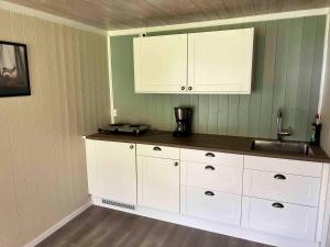 LusterDalsøren Camping og hytter的厨房配有白色橱柜和水槽