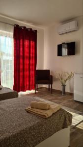 克拉多沃Apartmani KOKI Kladovo的一间卧室设有两张床和红色窗帘
