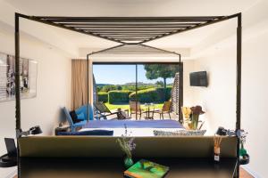 博尼法乔Hôtel & Spa Version Maquis Citadelle的一间卧室配有一张床,享有庭院的景色