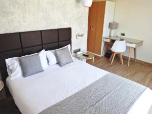 巴塞罗那略雷特兰布拉酒店的卧室配有一张白色大床和一张书桌