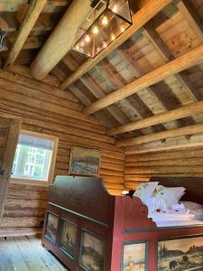 高尔Hesla Farm的配有木制天花板、一张床和图片的房间