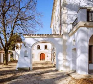 San Vicente de TorellóCan Passarells的带有拱门的白色建筑的入口
