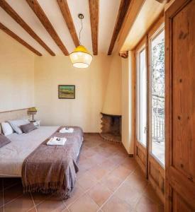 San Vicente de TorellóCan Passarells的一间卧室设有一张大床和一个壁炉