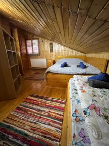 普雷代亚尔Casuta noastra din Predeal的配有木天花板的客房内的两张床