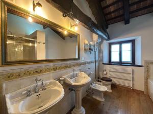 弗留利地区奇维达莱Lis Fadis Wine Relais的浴室设有2个水槽、镜子和卫生间。