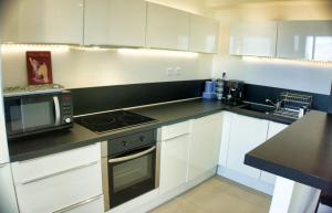 戛纳Ref MIDI - Palmes d'Or Properties的厨房配有白色橱柜和黑色台面