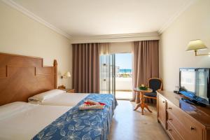 哈马马特Occidental Marco Polo的配有一张床和一台平面电视的酒店客房