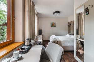 什恰夫尼察巴托丽酒店的酒店客房带一张床、一张书桌和一面镜子
