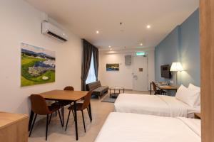 普崇The Signature Serviced Suites Puchong的酒店客房设有两张床和一张桌子。