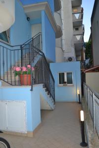 里米尼Residence Blu Marine的蓝色的建筑,有楼梯和盆栽花