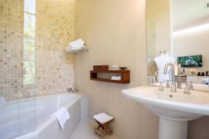 圣雷米普罗旺斯阿尔皮勒城堡酒店的浴室配有盥洗盆、浴缸和盥洗盆