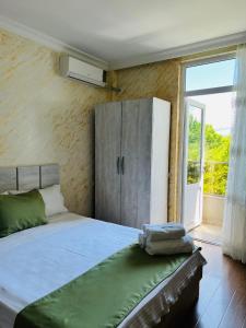巴统Apartments NITA的一间卧室配有一张带橱柜和窗户的床。